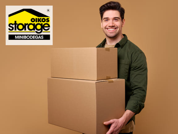 Persona sosteniendo cajas para guardar pertenencias en una minibodega